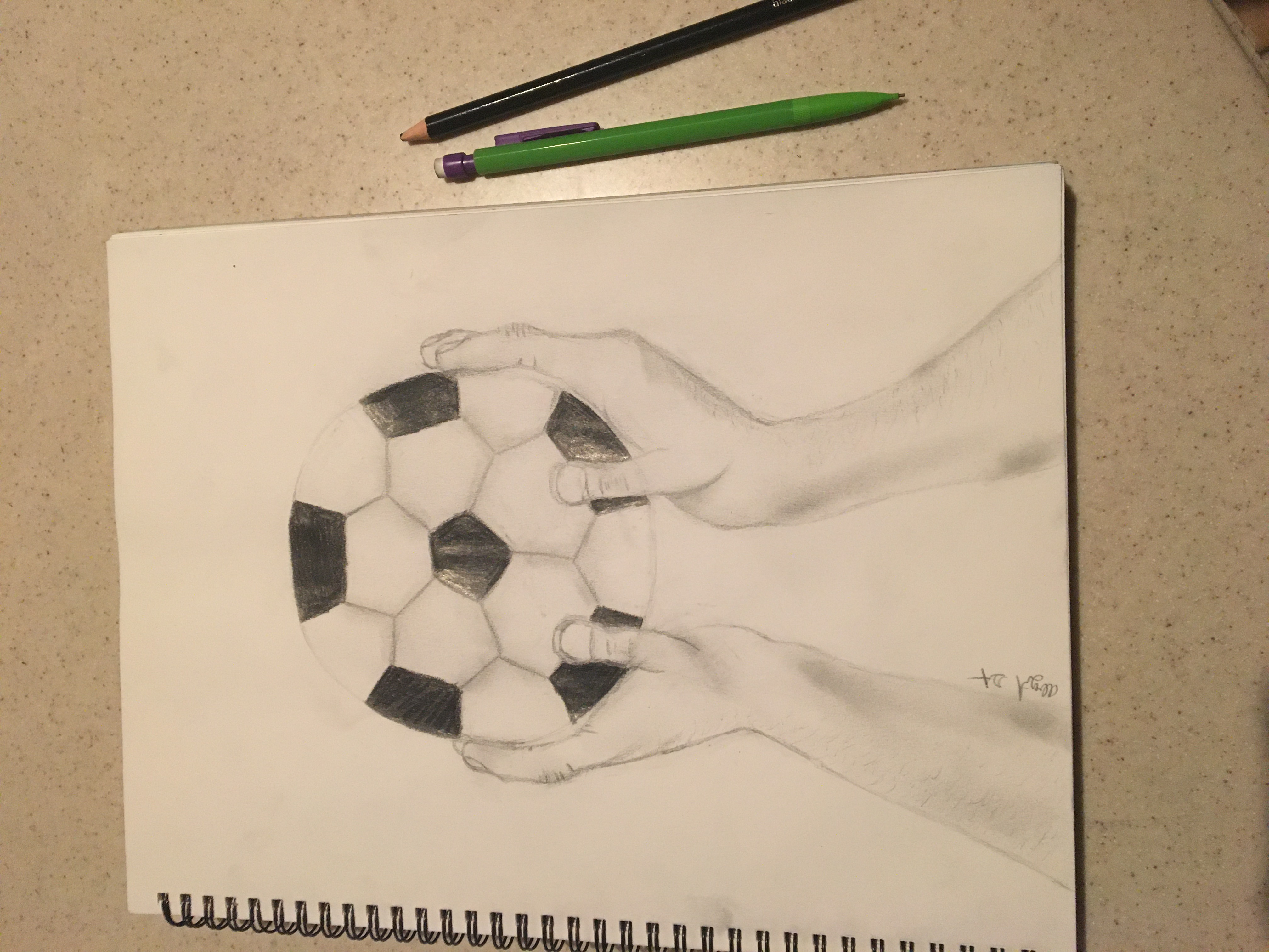 Pencil drawing of hands holding a soccer ball